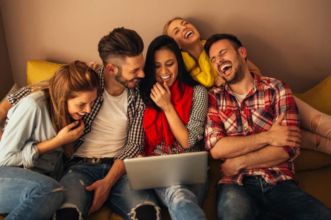 Studenten sitzen auf dem Sofa und lachen